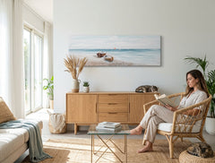 U boho stilu slika na platnu s motivom PLAŽA, okean, nebo, more i plaža u bijelo-bežih nijansama okačena u enterijeru dnevnog boravka, mirna atmosfera – enterijer